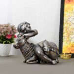 Handcrafted bronze idol of Lord Ganesha resting on a sacred cow, symbolizing divine harmony and peace.